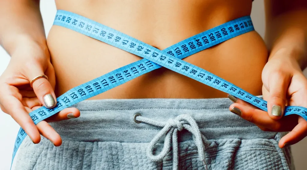 Fat loss tips 2025 – woman measuring waist with tape measure